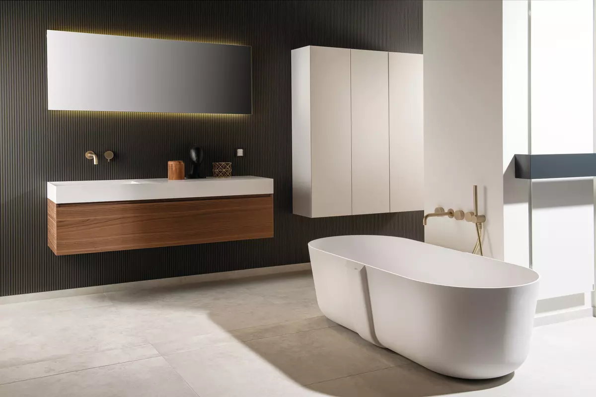 Filigrane freistehende Badewanne mit goldenen Armaturen in einem modernen Bad 