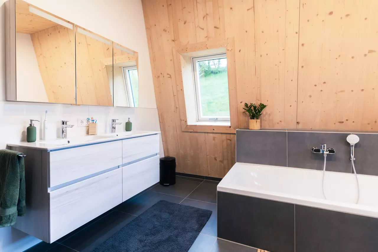 Badezimmer mit Holzwand, Waschtisch und Badewanne