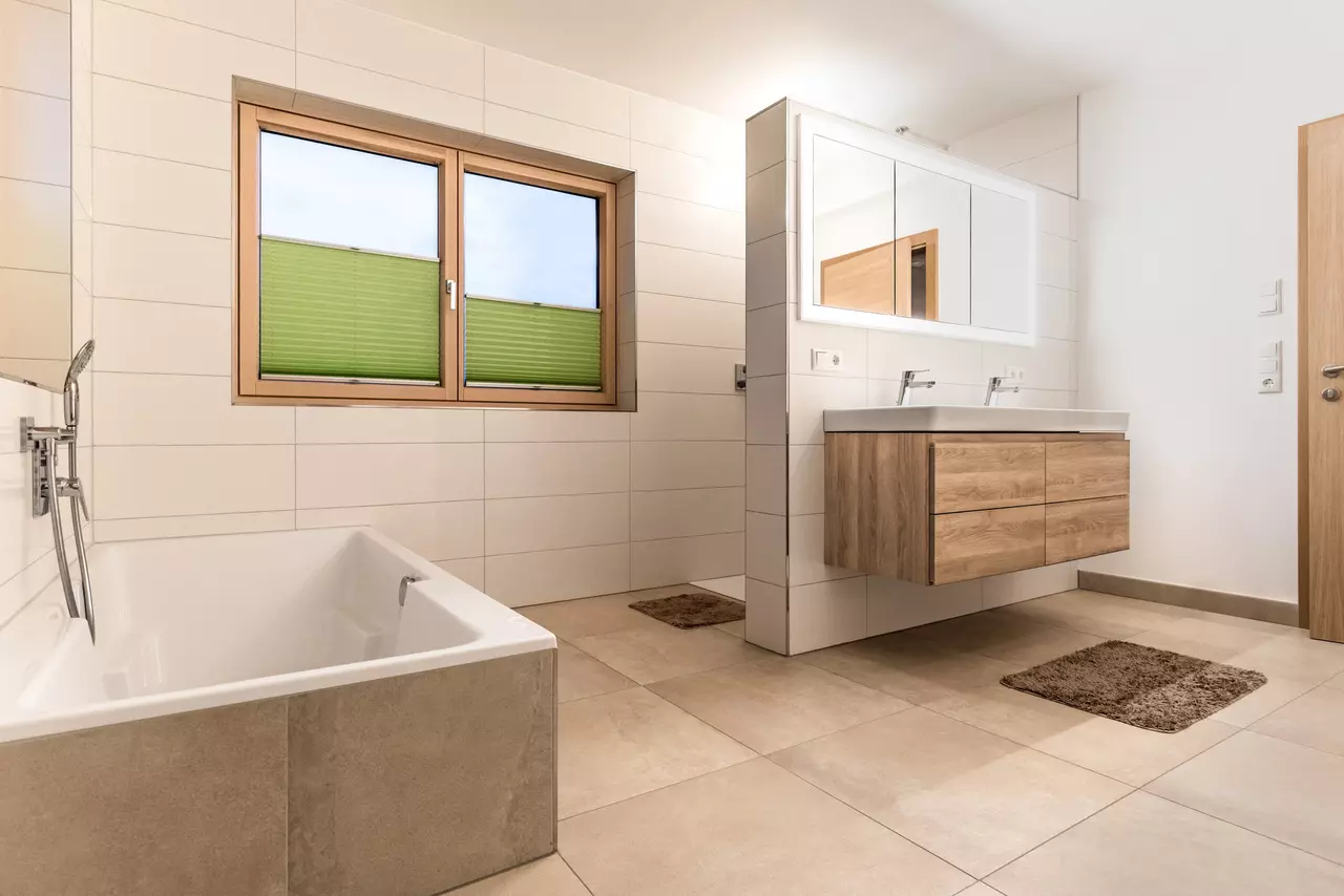Badezimmer mit Doppelwaschtisch, Spiegelschrank, Badewanne und Dusche
