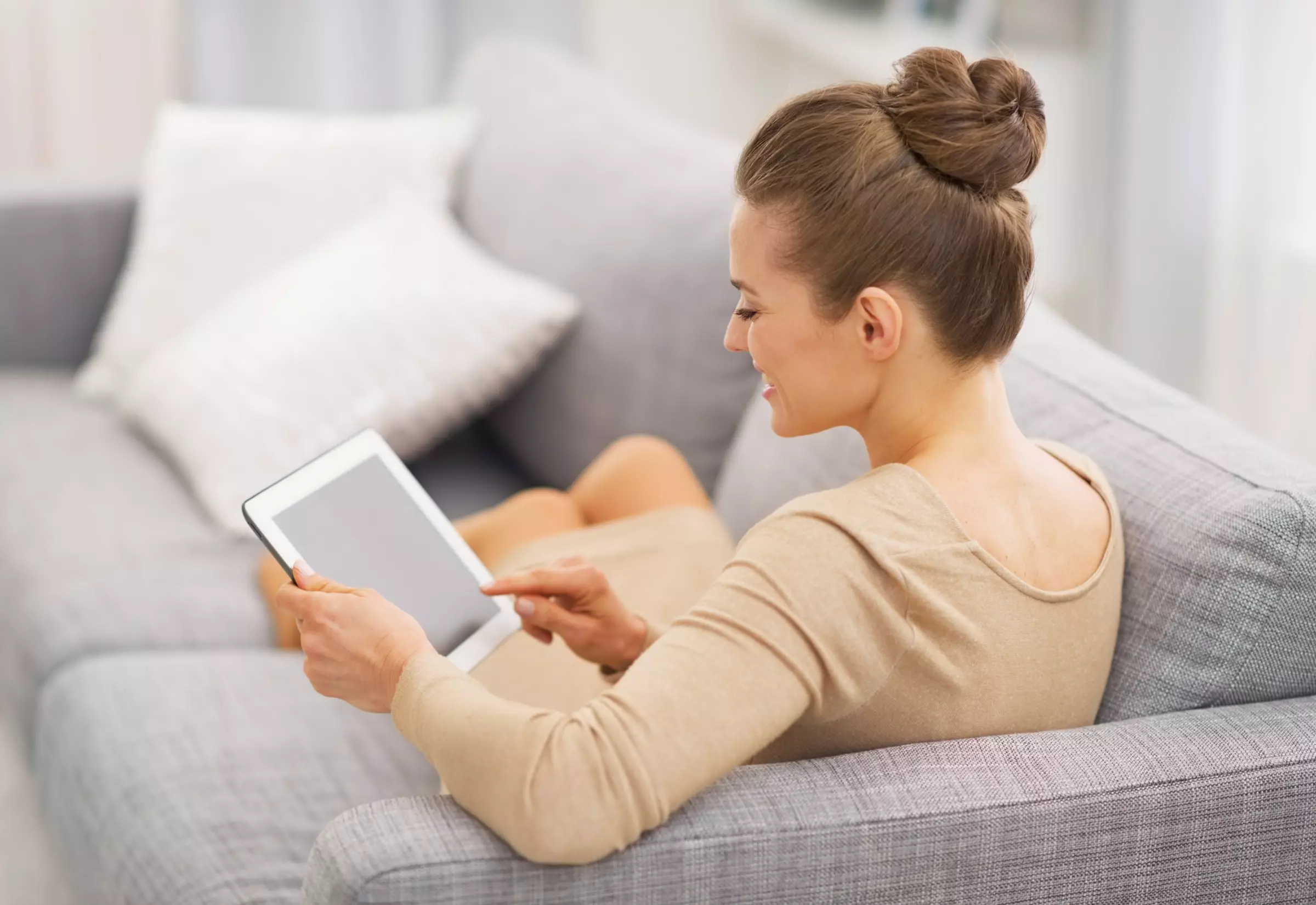 Frau auf Couch mit Tablet